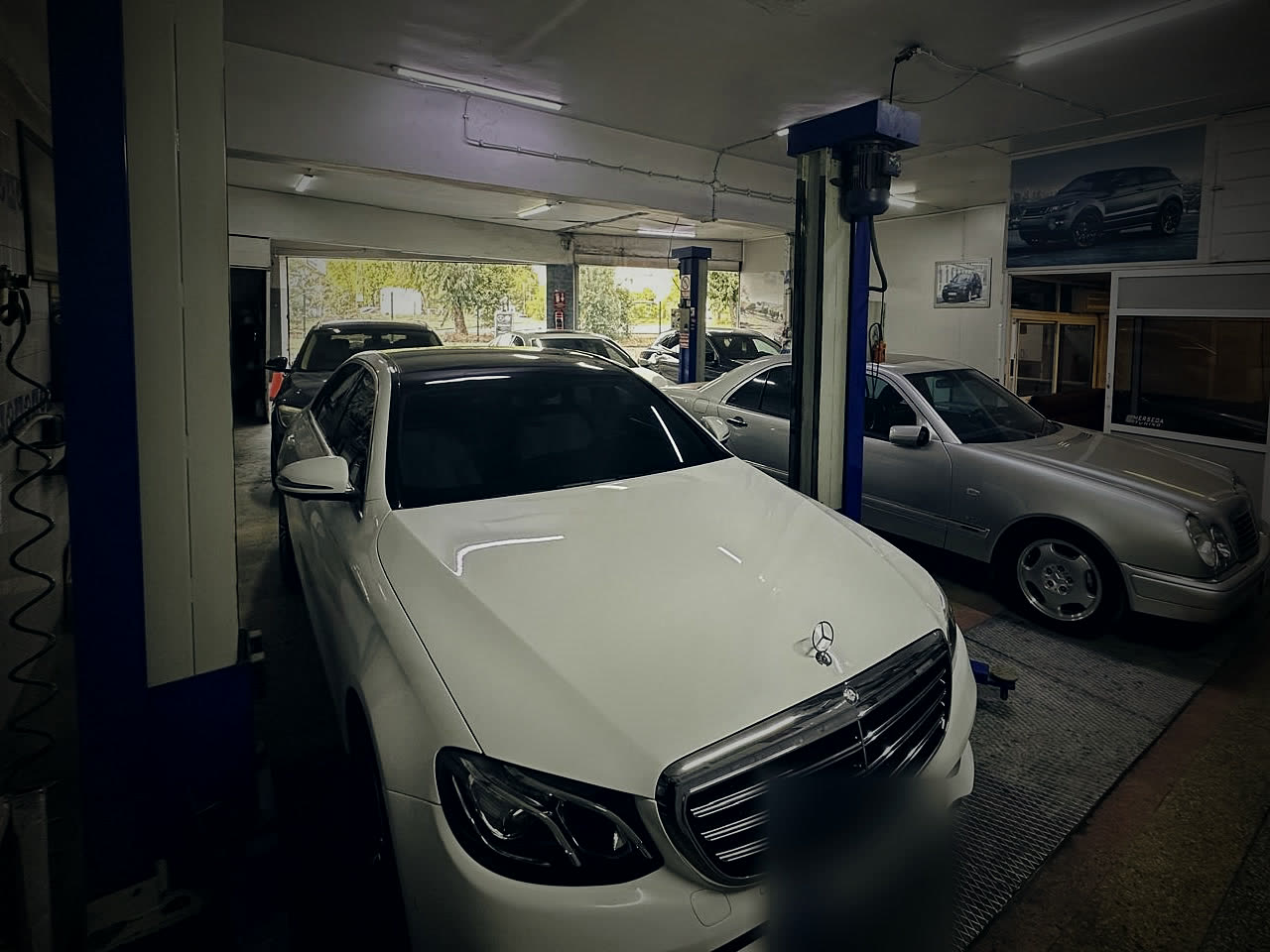 Merseda Oto atölyesinde lift başında beyaz Mercedes-Benz E Serisi ve gümüş CLK